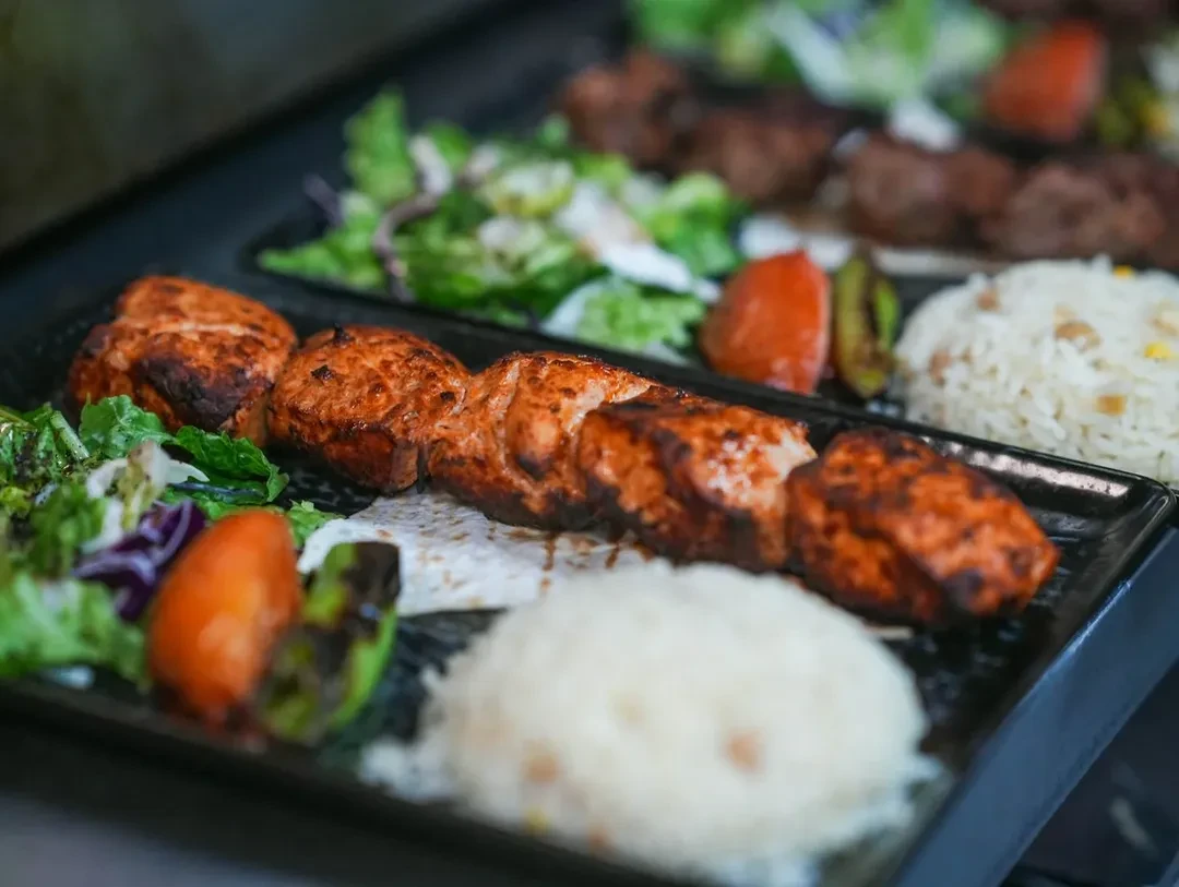 Salmon skewer with rice and vegetables on a tray